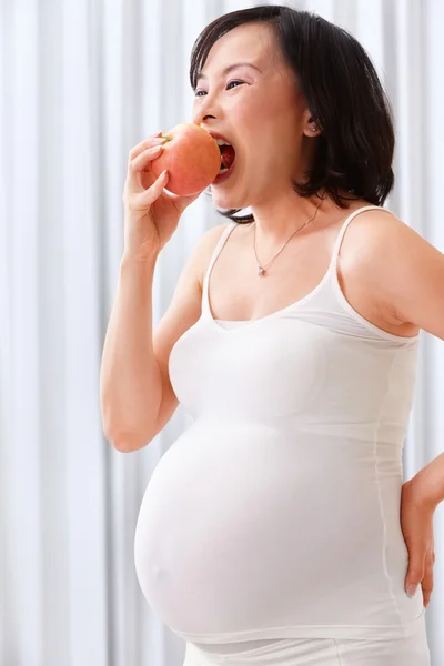 Terhes hölgy étkezési Alma — Stock Fotó