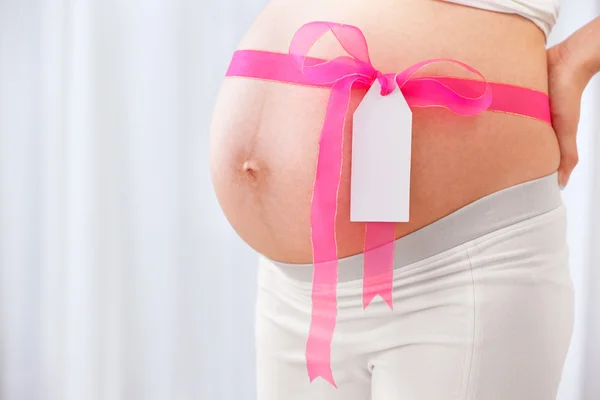 Ruban rose arround ventre de femme enceinte — Photo