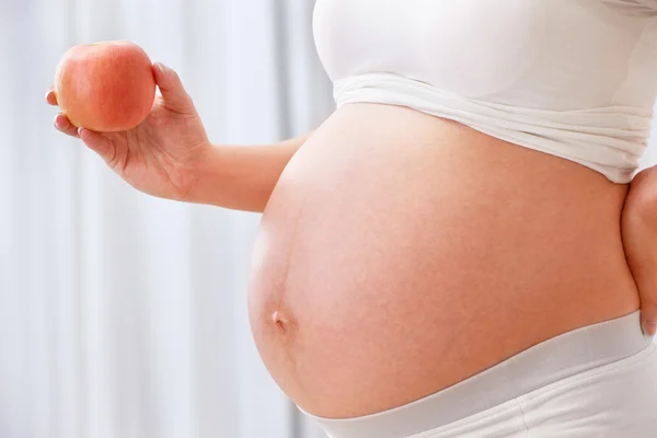 Femme enceinte tenant pomme — Photo