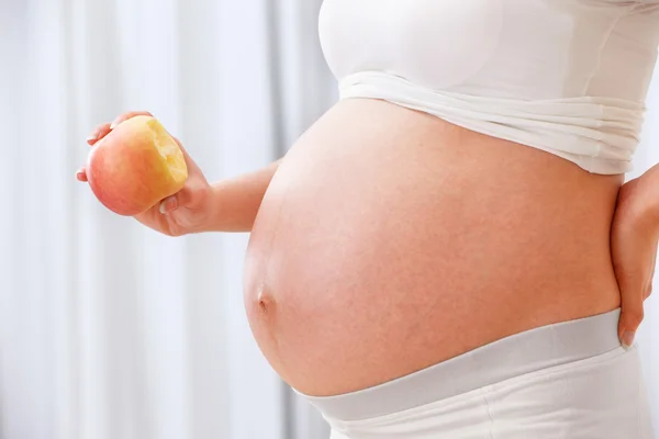 Hamile kadının holding elma — Stok fotoğraf