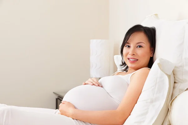 Pregnant lady resting on bed — Stock Photo, Image
