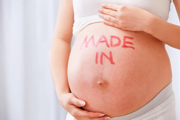 Stomaco di donna incinta con Made in word — Foto Stock
