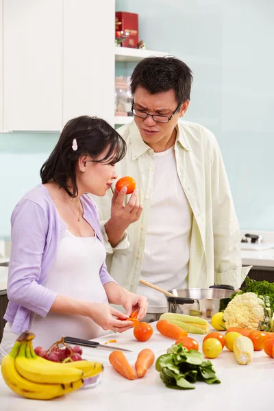Asian couple busy in kitchen — Stock Photo, Image