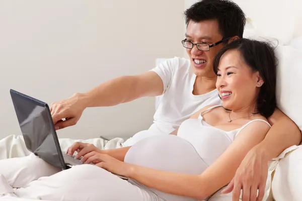 Pani w ciąży i jej mąż za pomocą laptopa — Zdjęcie stockowe