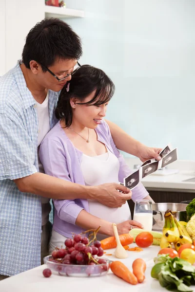 Asian couple looking at USG fetus picture — Stock Photo, Image