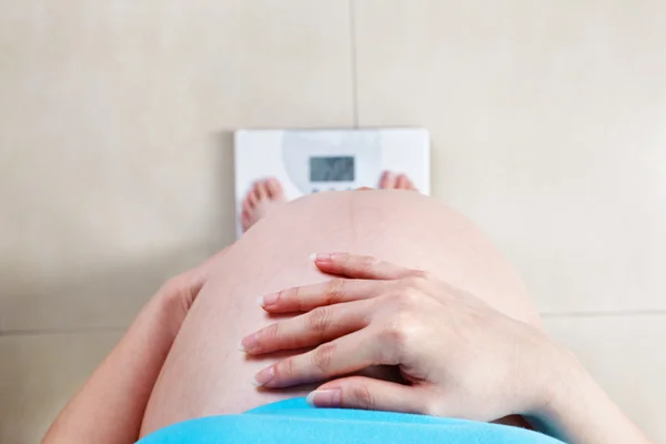 Těhotná žena měření její váha — Stock fotografie