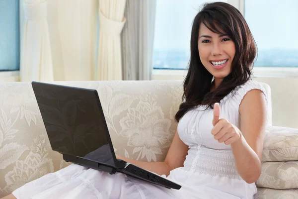 Junge Frau benutzt Laptop mit erhobenem Daumen — Stockfoto