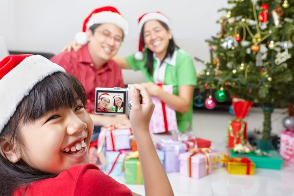 Маленькая девочка фотографирует своих родителей на Рождество — стоковое фото