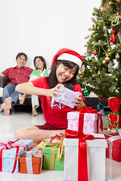 Klein meisje bezig met haar kerstcadeau — Stockfoto