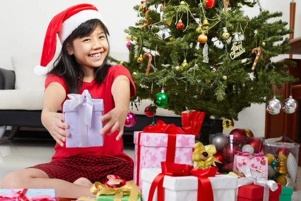 Noel hediyesi işaret eden küçük kız — Stok fotoğraf
