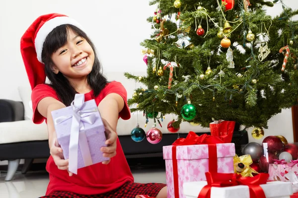 Маленькая девочка указывает на подарок на Рождество — стоковое фото