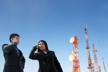 Asian business on phone and antenna clipart