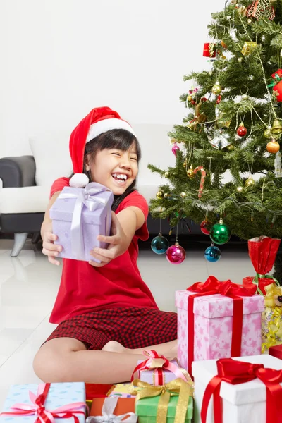 Little girl pointing Christmas present — Stock Photo, Image
