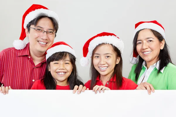 Family pose in front of blank paper — Stock Photo, Image