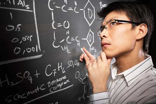 Студент-мужчина работает над уравнением — стоковое фото