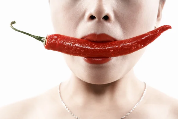 Woman holding big red chili in mouth — Stock Photo, Image