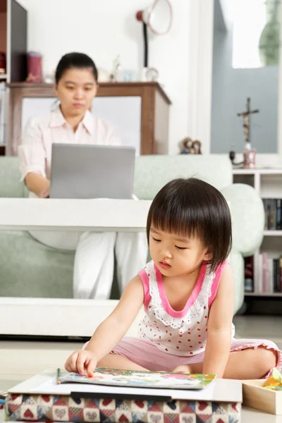 Liten flicka spela medan hennes mamma arbetar — Stockfoto
