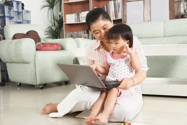 Mãe e filha jogando laptop juntos — Fotografia de Stock