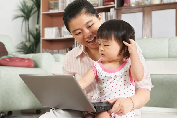 Moeder en dochter spelen laptop samen — Stockfoto