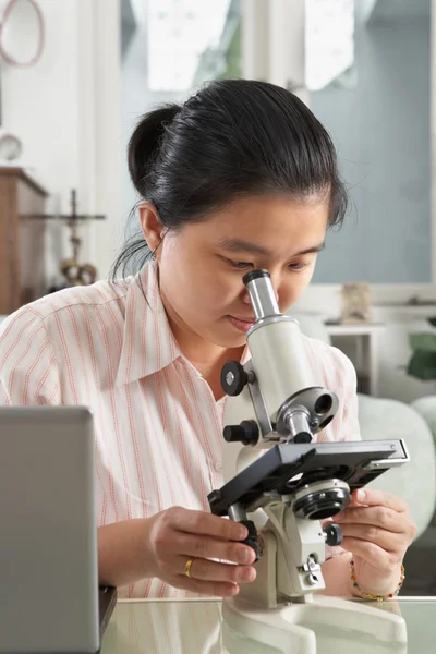 Κινεζική γυναίκα που εργάζεται με μικροσκόπιο — Φωτογραφία Αρχείου