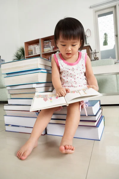 Litlle menina lendo lotes de livros — Fotografia de Stock