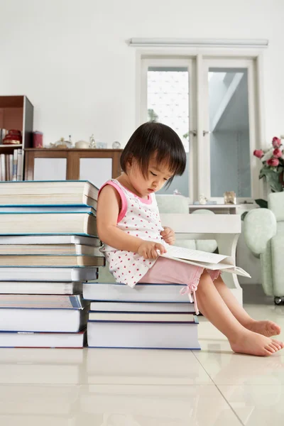 Litlle flicka läsa massa böcker — Stockfoto