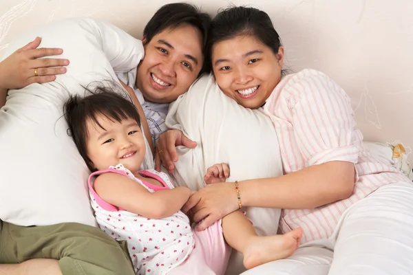Familia china divertirse en la cama — Foto de Stock