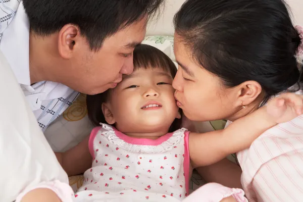 Föräldrar kyssas dotter — Stockfoto
