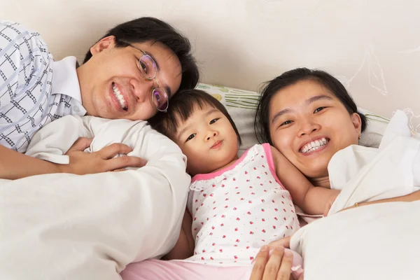 Família chinesa se divertindo na cama — Fotografia de Stock