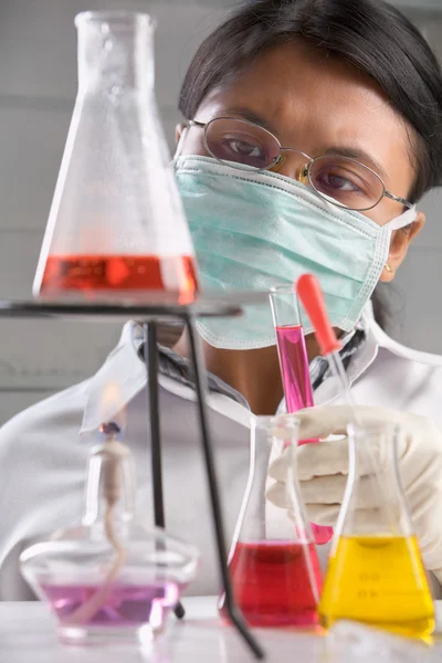 Cientista examinando solução química fervida — Fotografia de Stock