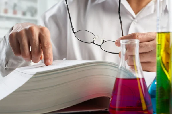 Scientist looking for data in journal — Stock Photo, Image