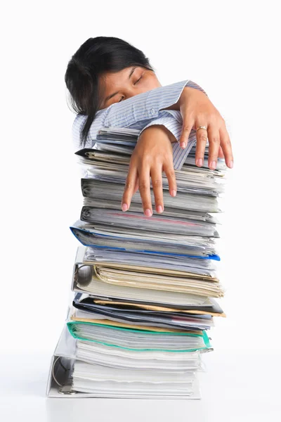 Woman tired behind pile of paper — Stock Photo, Image