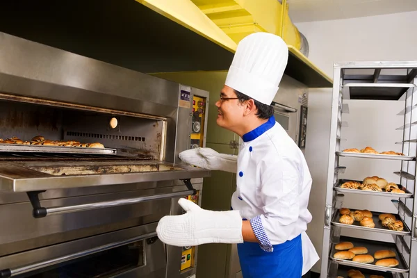 Überprüfung des Brotes im Ofen — Stockfoto