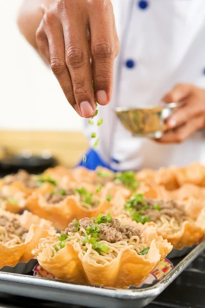 Sprinkle herbs on noodle — Stock Photo, Image