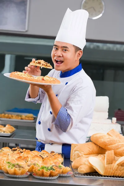 Chef eating the pizza — Stock Photo, Image