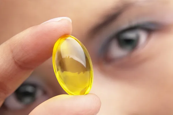 Holding vitamin capsule — Stock Photo, Image