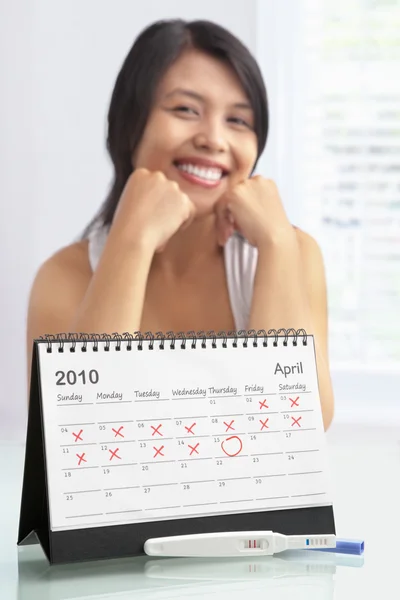 Ευτυχισμένη γυναίκα με θετικό τεστ εγκυμοσύνης και ημερολόγιο — Φωτογραφία Αρχείου
