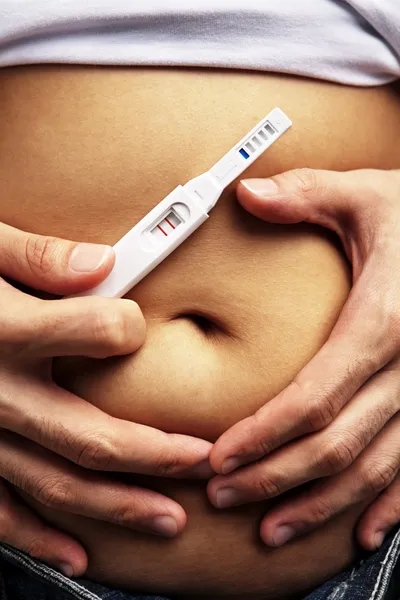 Manlig hand omfamna pregnanct mage — Stockfoto