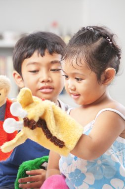 Asian sibling playing hand puppet clipart