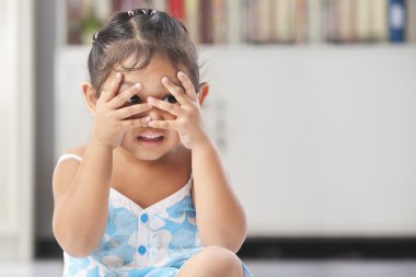 Little girl playing peekaboo clipart