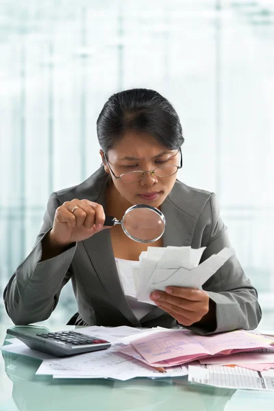 Asian bussinesswoman checking bills — Stock Photo, Image