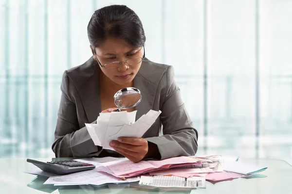 Asiatiska affärskvinna Kontrollera räkningar med förstoringsglas — Stockfoto