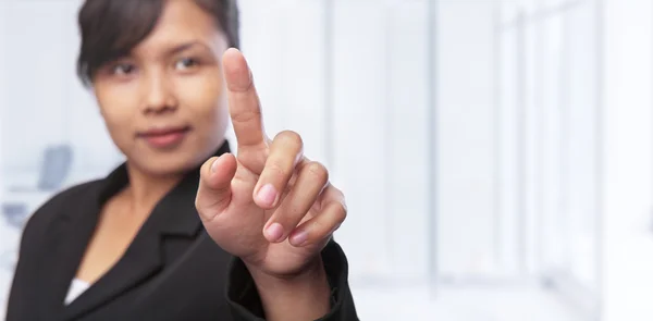 Asian businesswoman pointing at blank space in office — Stock Photo, Image