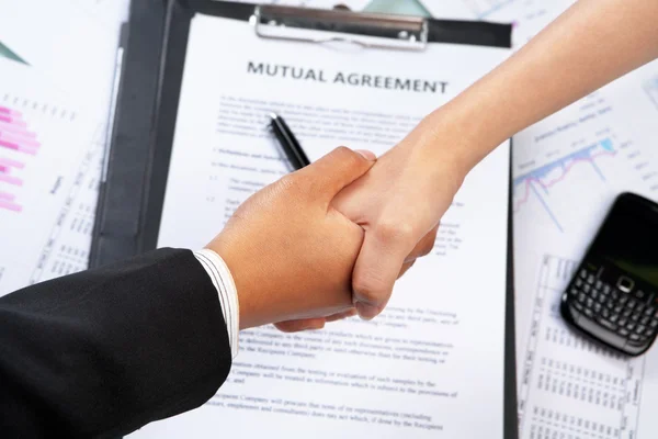 Handshake btween businesswoman over agreement — Stock Photo, Image
