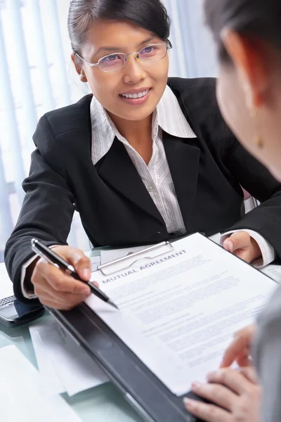 Mujer de negocios asiática explicando documento al cliente — Foto de Stock