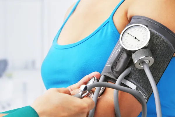 Verificando a pressão arterial de paciente do sexo feminino — Fotografia de Stock