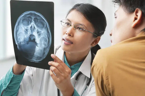 Médecin expliquant la radiographie du squelette au patient — Photo