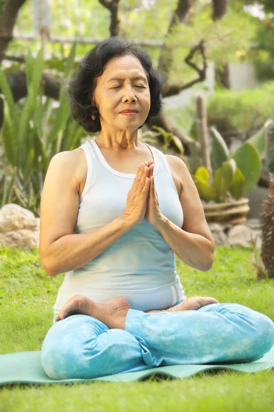 Asiática senior mujer meditando para yoga fuera — Foto de Stock