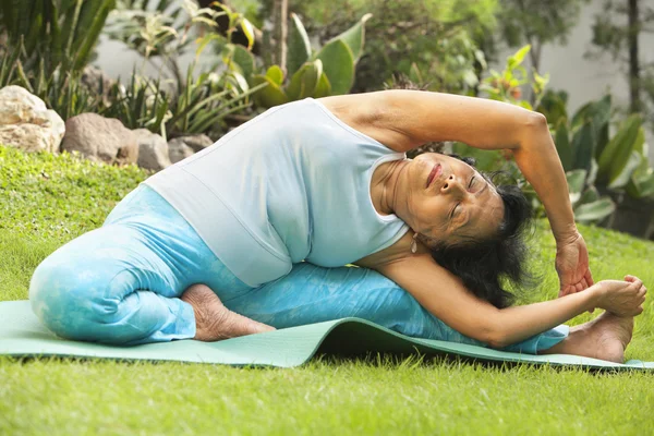 Senior woman doing yoga at park — Stock Photo, Image