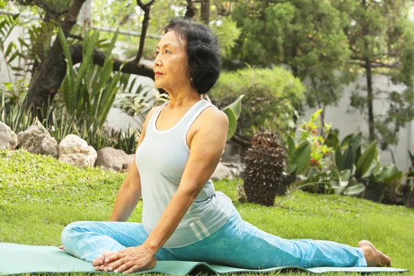 Senior woman doing yoga at park — Stock Photo, Image